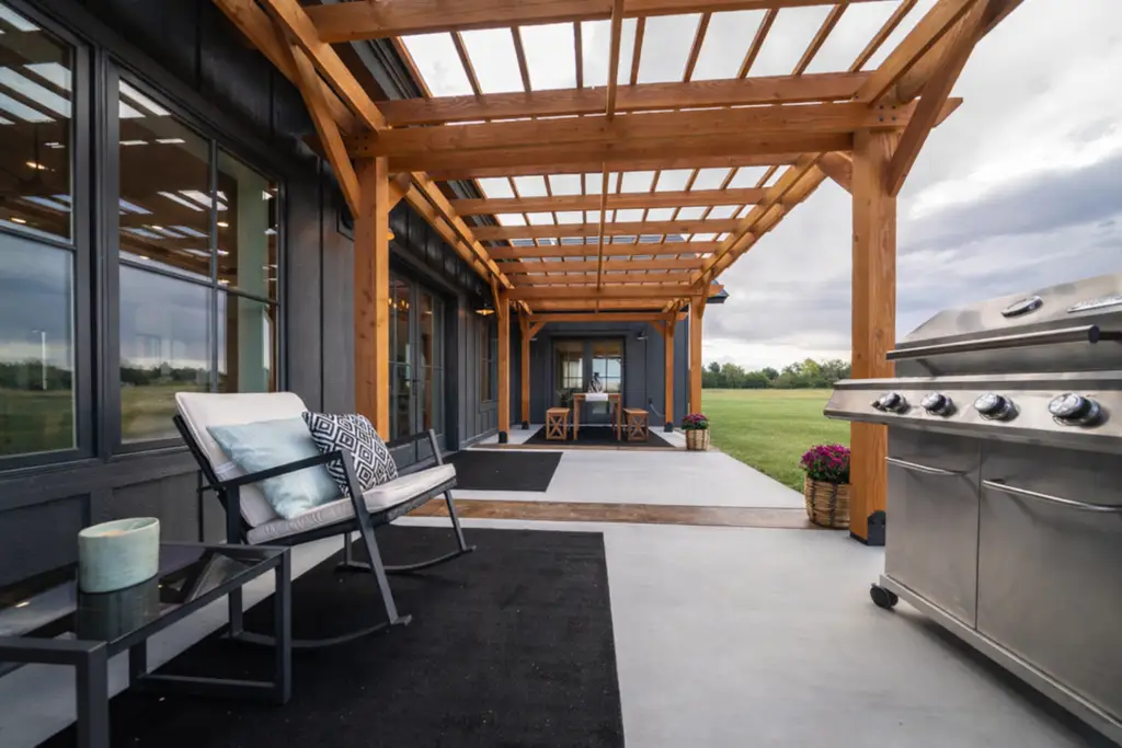 Covered outdoor living space with a timber pergola, spacious patio, and built in grilling area designed for year round entertaining.